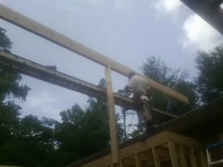 Carpenter setting a ridge beam over a new addition frame — Ice Dam Removal by Roofing Brothers in New Lebanon