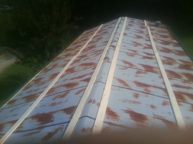 Rusted metal roof panels with new wood purlins before replacement — Storm Damage Roof Repair in New Lebanon by Roofing Brothers
