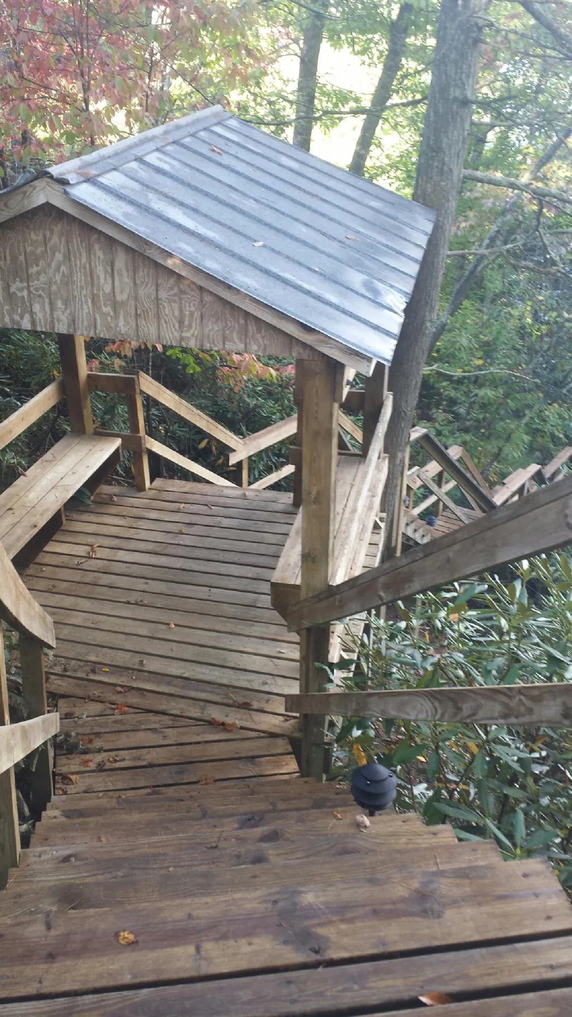 Metal roofed shelter over wooden steps on a wooded walkway — Skylight Repair & Installation work by our crew in New Lebanon