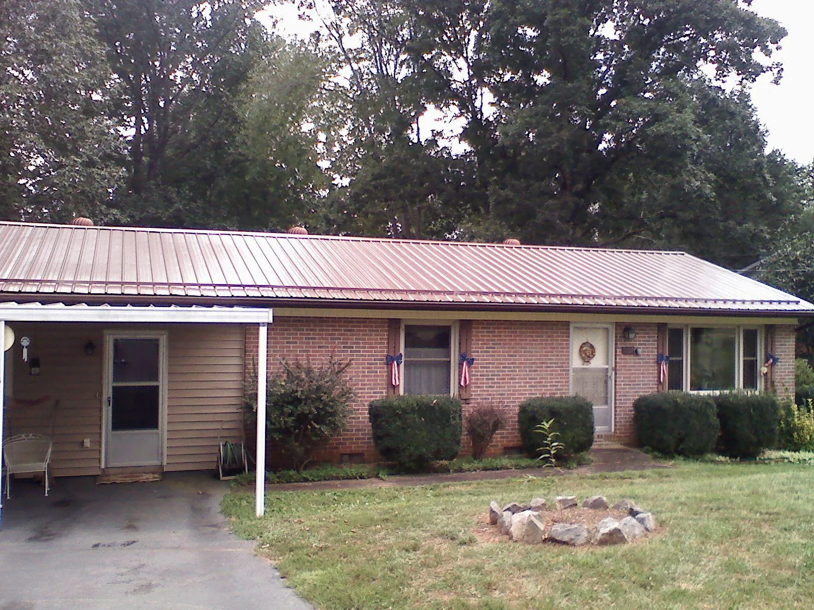 Bronze metal roof and carport on a brick ranch home — Roof Repair work by our crew in New Lebanon